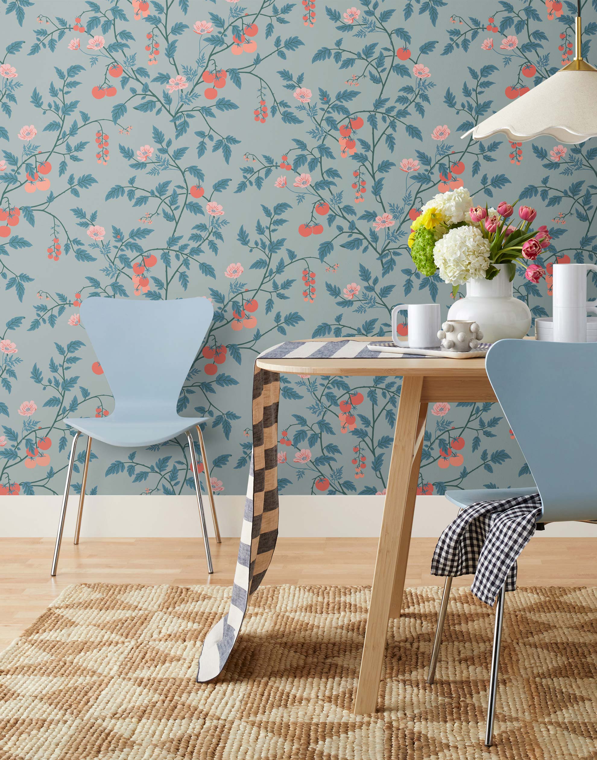 Our Heirloom wallpaper celebrates the annual arrival of tomato season. Highly durable, fade resistant, and made in the USA. This wallpaper features red and peach tomatoes, pink flowers and blue vines on a light blue background and was created in collaboration with The Aesthetics of Joy.