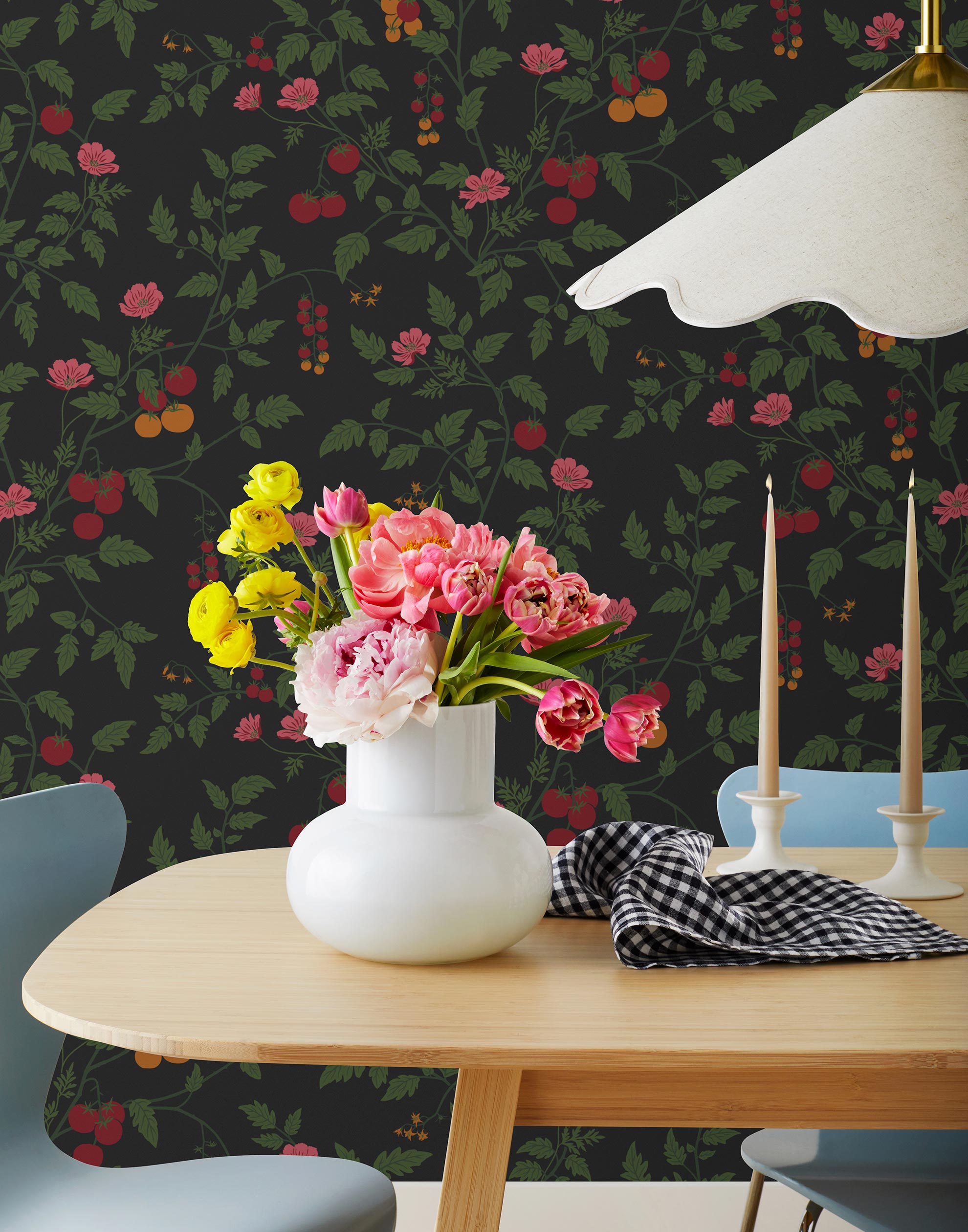 Our Heirloom wallpaper celebrates the annual arrival of tomato season. Highly durable, fade resistant, and made in the USA. This wallpaper features red and orange tomatoes, pink flowers and green vines on a black background and was created in collaboration with The Aesthetics of Joy.