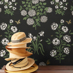 This large-scale wallpaper features hand drawn bees, butterflies and other garden friends frolic among flowers - camellias, hellebores, irises, and snowball trees. Harmony (Ebony) is printed in shades of green and white on a black background.