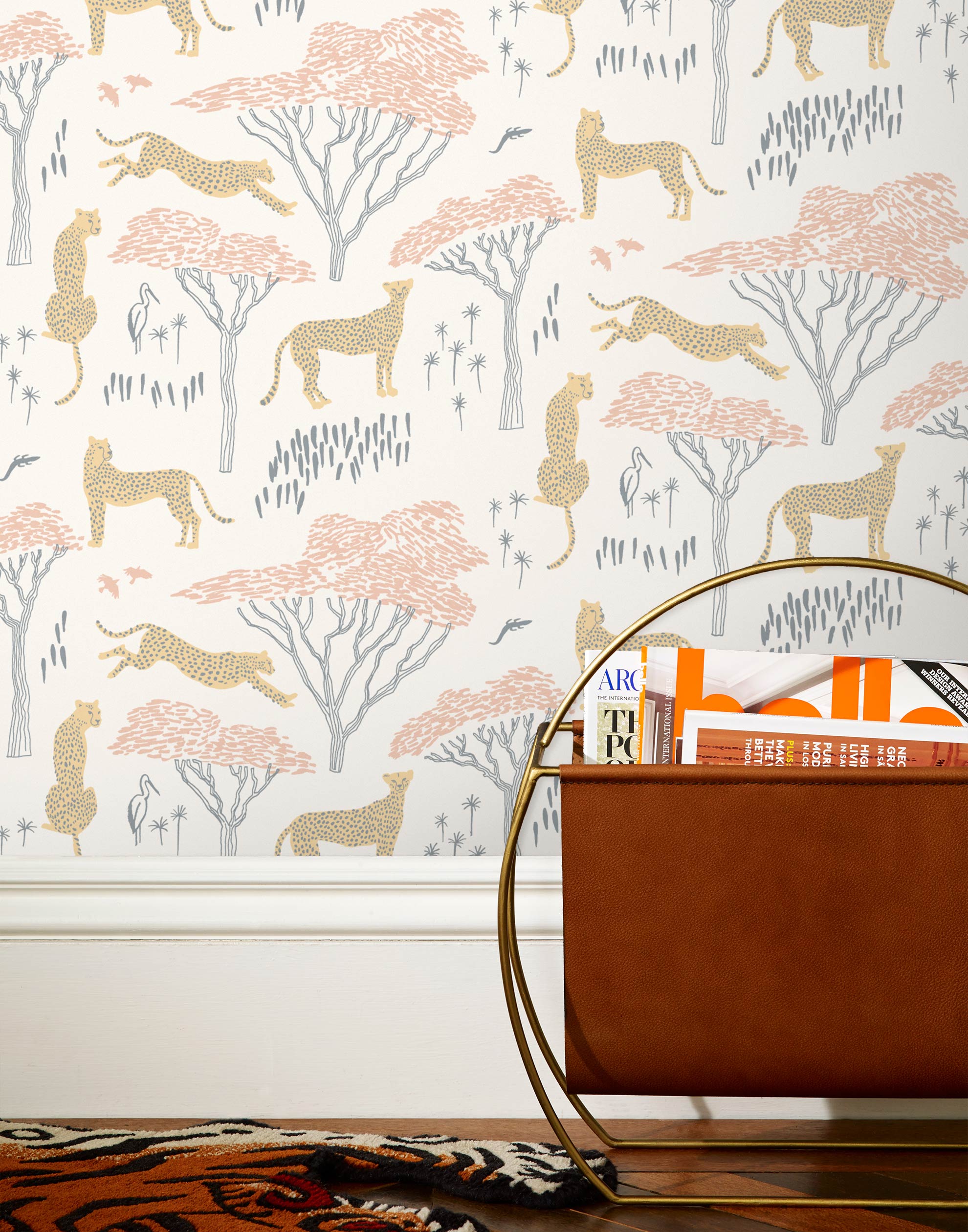Our Serengeti wallpaper features beige cheetahs and pink birds scattered among peach acacia trees on a white background, reflecting the powerful beauty of the vast plains. Designed by Julia Rothman and made in the USA.