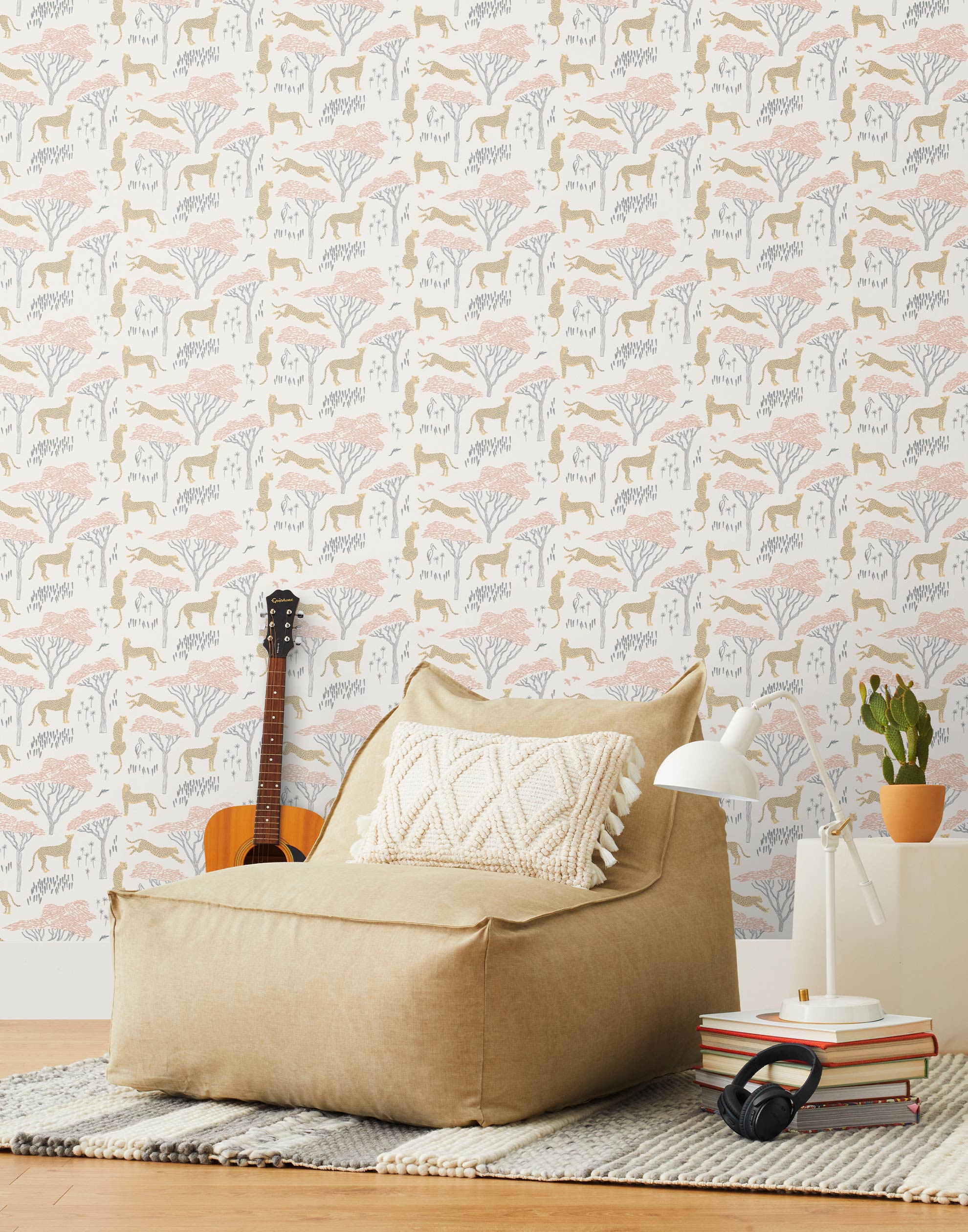 Our Serengeti wallpaper features beige cheetahs and pink birds scattered among peach acacia trees on a white background, reflecting the powerful beauty of the vast plains. Designed by Julia Rothman and made in the USA.